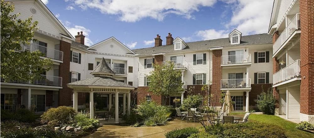 A charming residential building with a well-maintained garden under a clear blue sky.