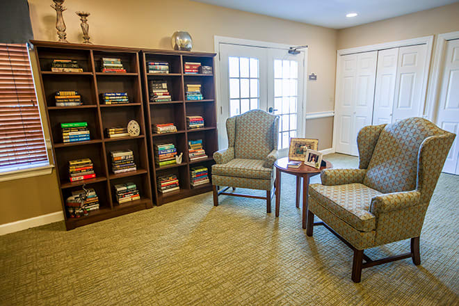 A cozy reading room with bookshelves and comfortable chairs.