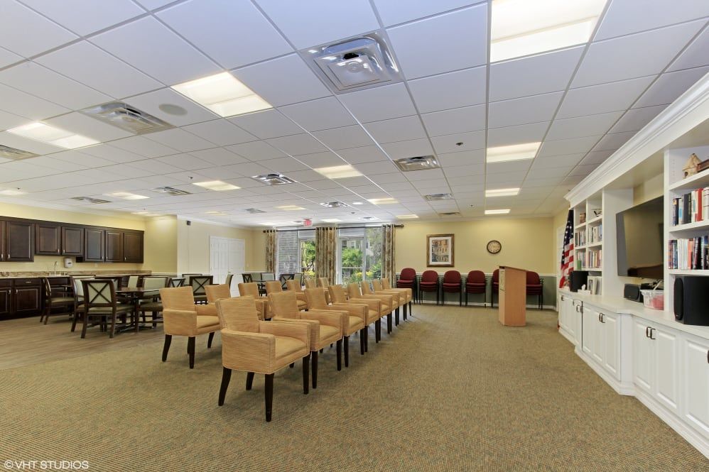 A spacious room with rows of chairs, a podium, and bright lighting.