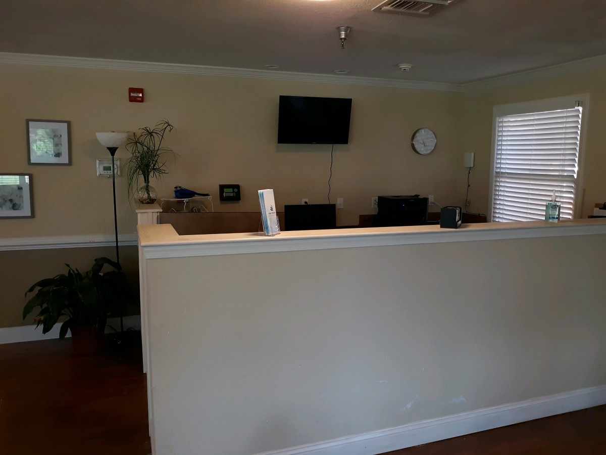 Reception area with a desk, television, and clock on the wall.