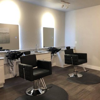 Modern barbershop interior with styling chairs and mirrors.