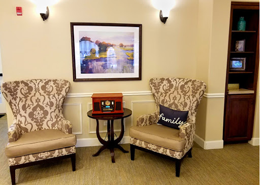 A cozy corner featuring elegant chairs, a small side table, and a beautiful piece of wall art.