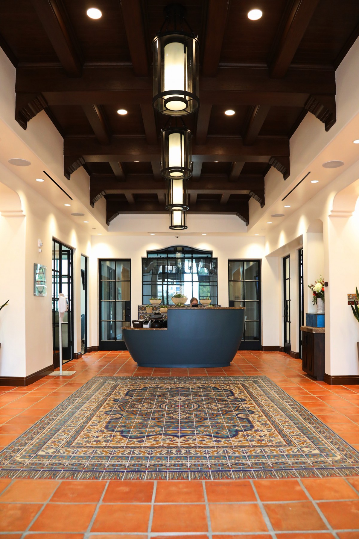 A beautifully designed lobby area featuring a reception desk, elegant lighting fixtures, and a patterned rug.