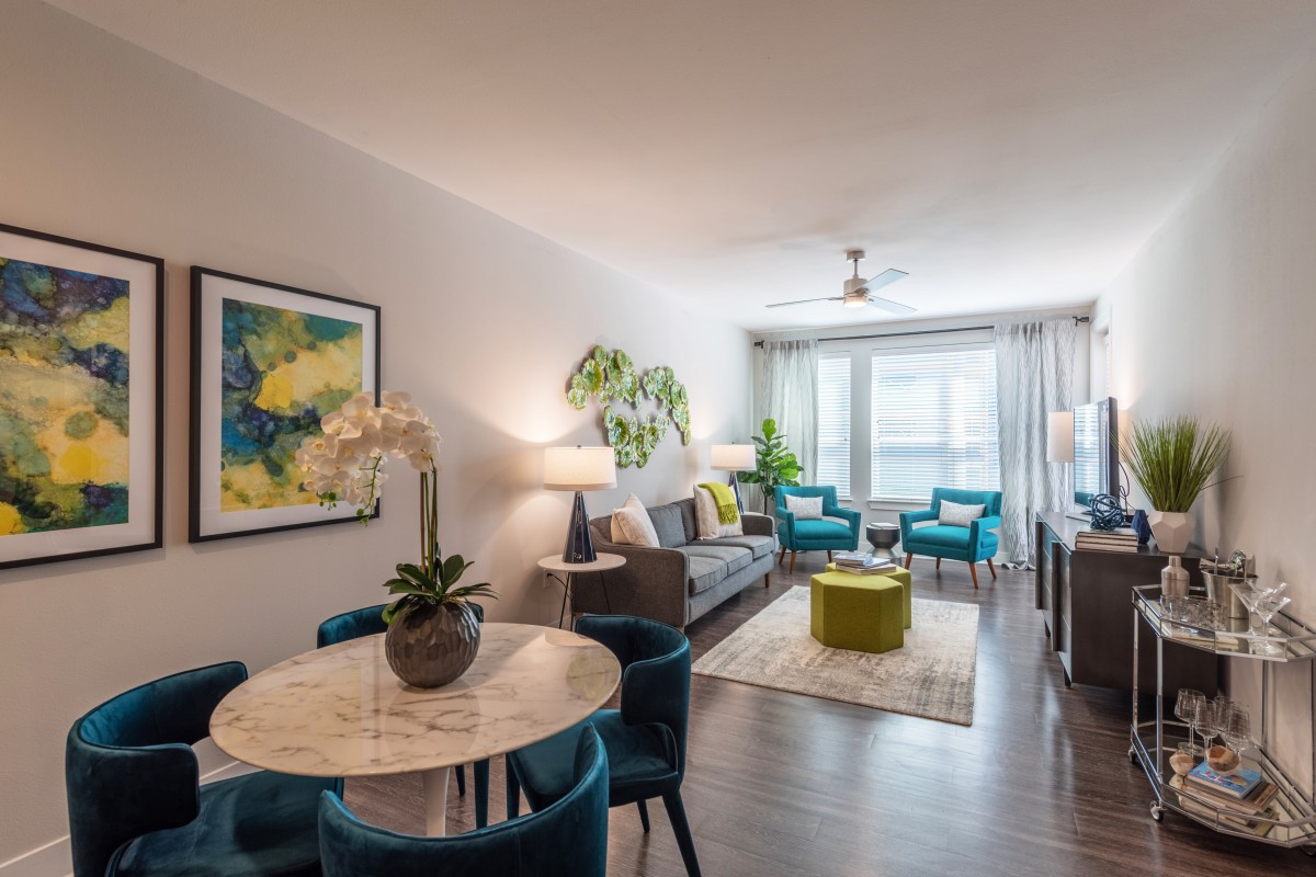 A modern living room with stylish furniture, vibrant decor, and large windows for natural light.