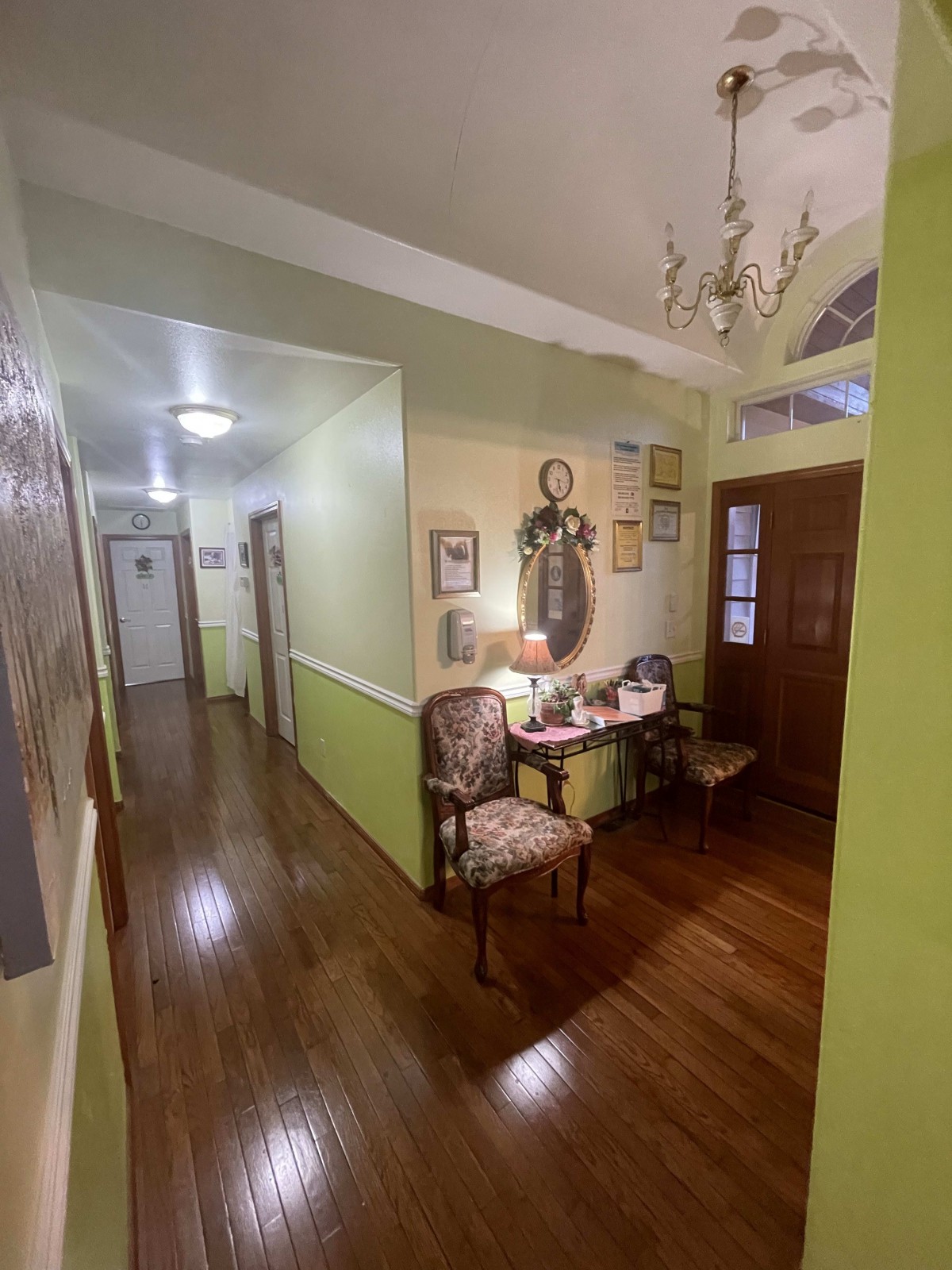 A cozy hallway with a wooden floor, featuring elegant furniture and decorated walls.