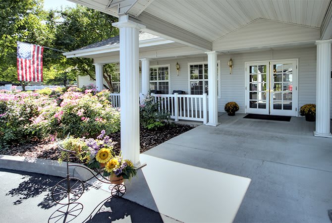 A charming house with a spacious porch and a colorful garden.