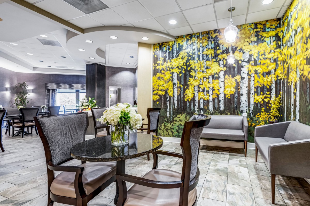 A stylish lobby with modern seating, floral decorations, and vibrant wall art.