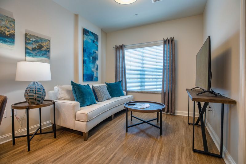 A modern living room with a comfortable sofa, elegant artwork, and ample natural light.