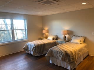 A cozy bedroom featuring twin beds and soft lighting.