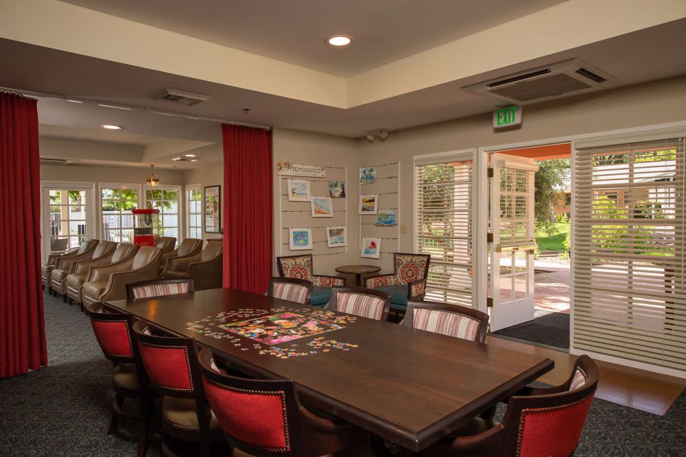 A well-lit conference room with a large table and chairs, featuring decorated walls and natural light from the windows.