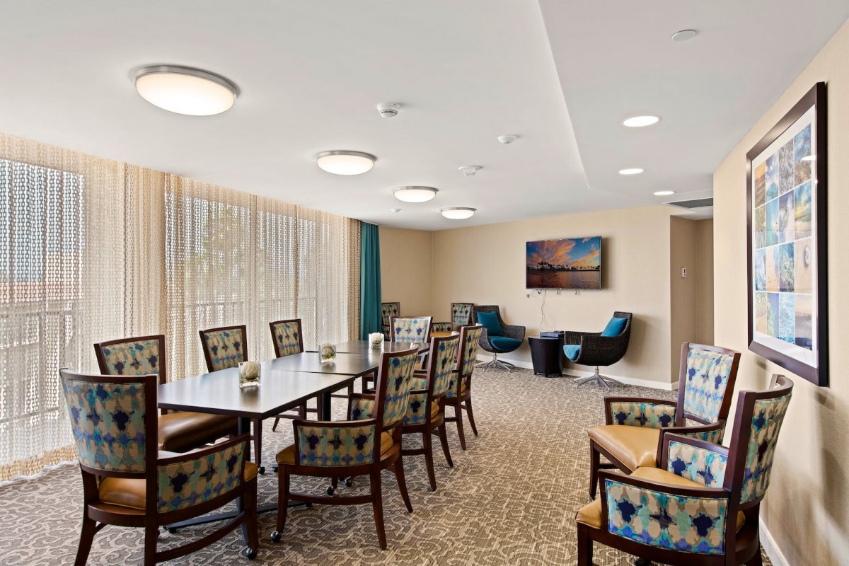 A modern conference room with a long table, chairs, and comfortable seating area.