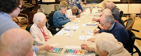 A group of seniors participating in an art activity at a community center.