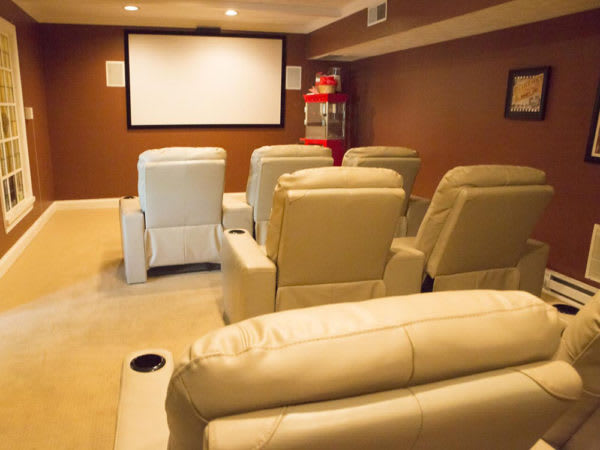 A cozy home theater setup with comfortable recliner seats and a large projector screen.