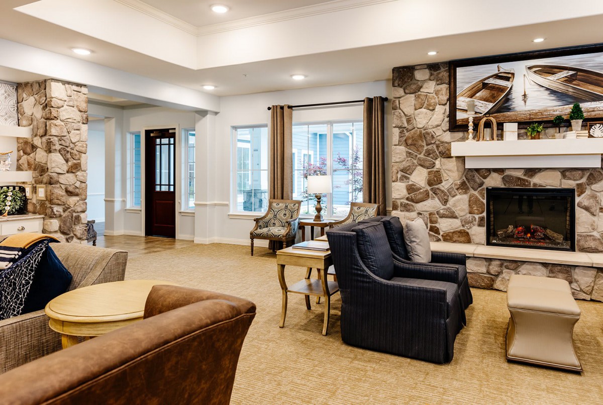 A cozy living room with modern furniture and a stone fireplace.