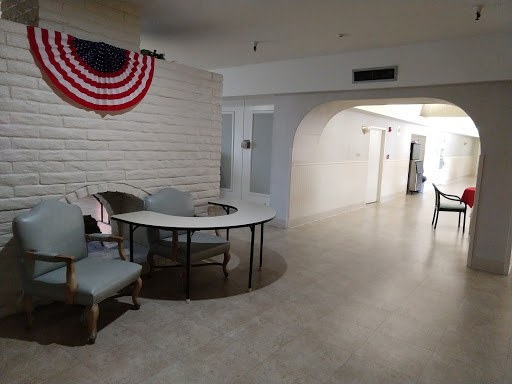 A spacious interior room featuring a table and chairs, decorated with an American flag.