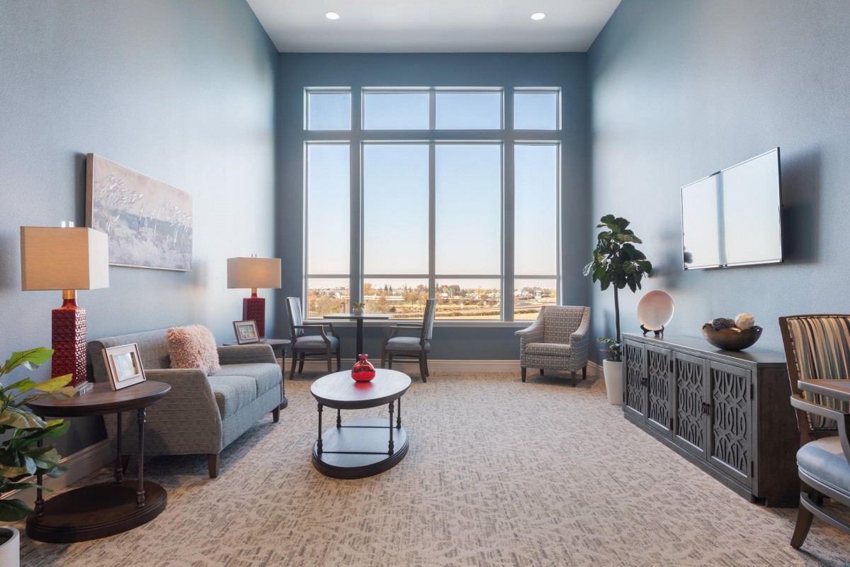 A modern living room with large windows, comfortable seating, and stylish decor.