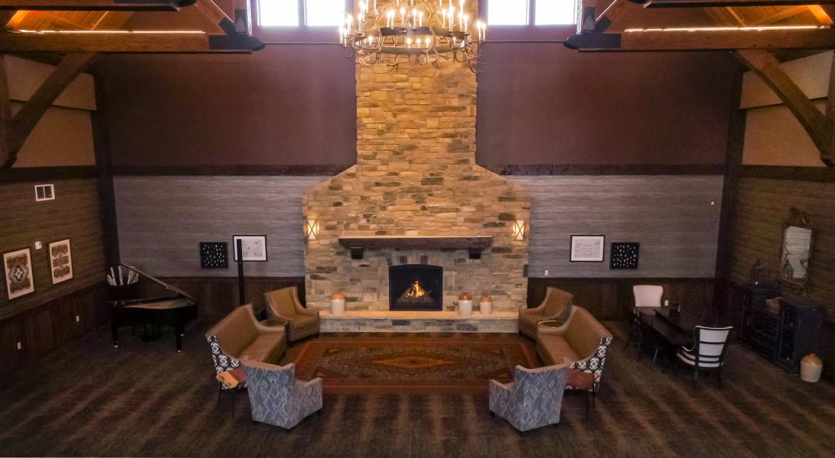 A cozy lounge area with a central stone fireplace and comfortable seating.