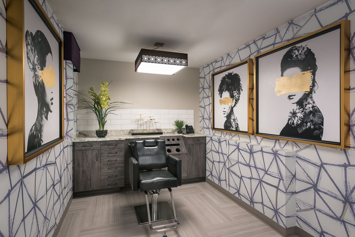 A modern hair salon interior with stylish artwork and a comfortable barber chair.