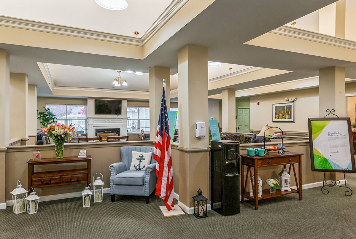 An inviting lobby area with comfortable seating and decorative elements, featuring a water dispenser and an American flag.