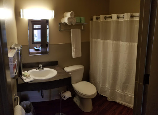 A well-organized bathroom featuring a shower, toilet, and sink.
