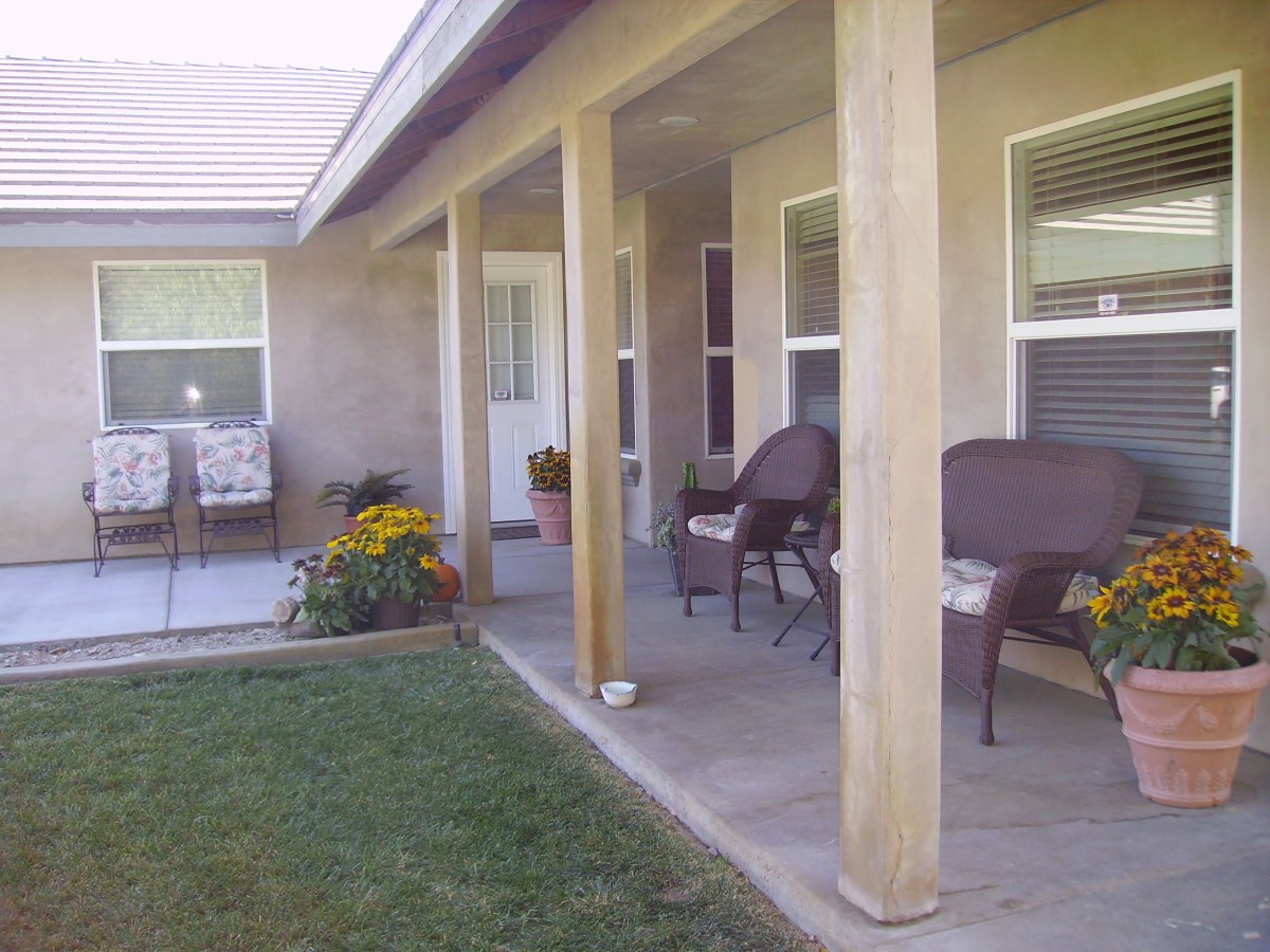 A cozy patio area with chairs and a garden in the backyard.