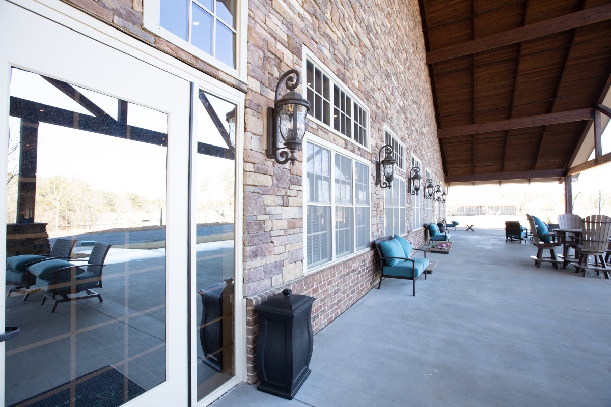 A spacious patio with comfortable outdoor seating and classic stone wall accents.