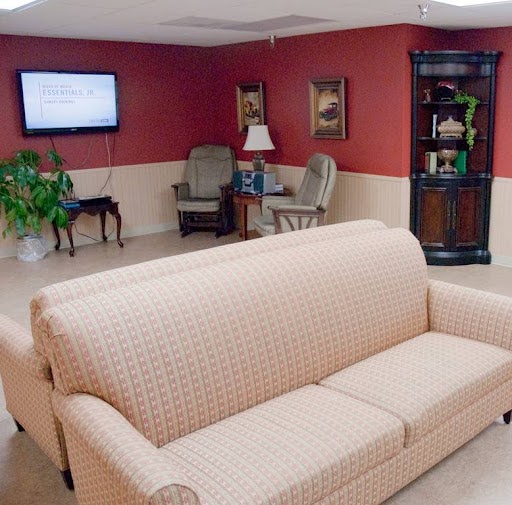 A cozy living room setup featuring a light-colored sofa, a television, and comfortable seating options.