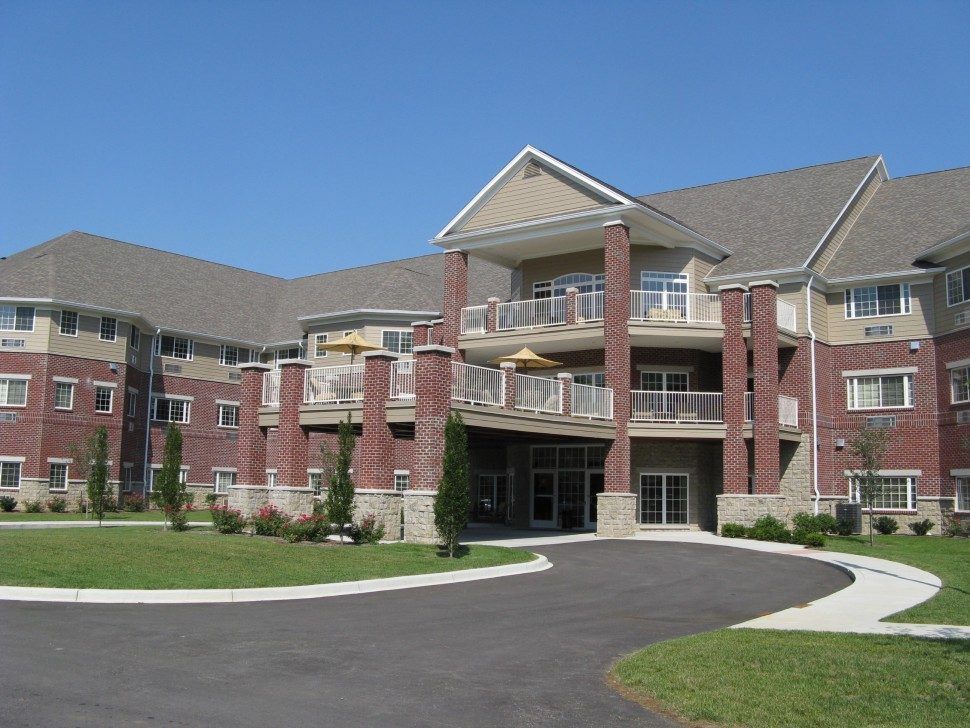 A modern residential apartment building with a landscaped driveway.