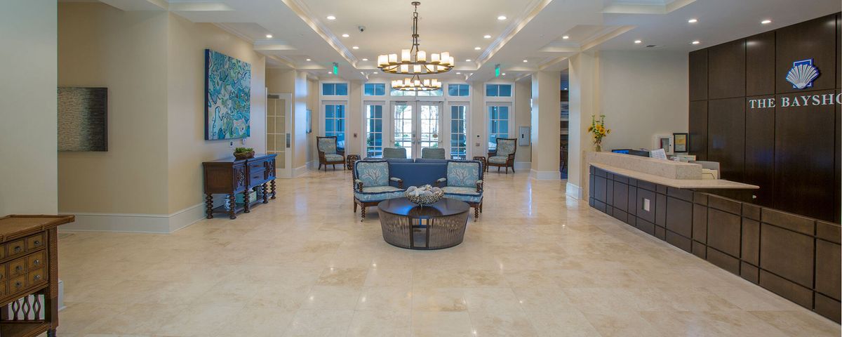 A spacious and modern lobby with elegant furnishings and a central chandelier.