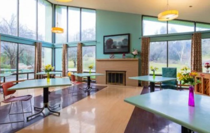 A modern dining area with large windows and a fireplace.