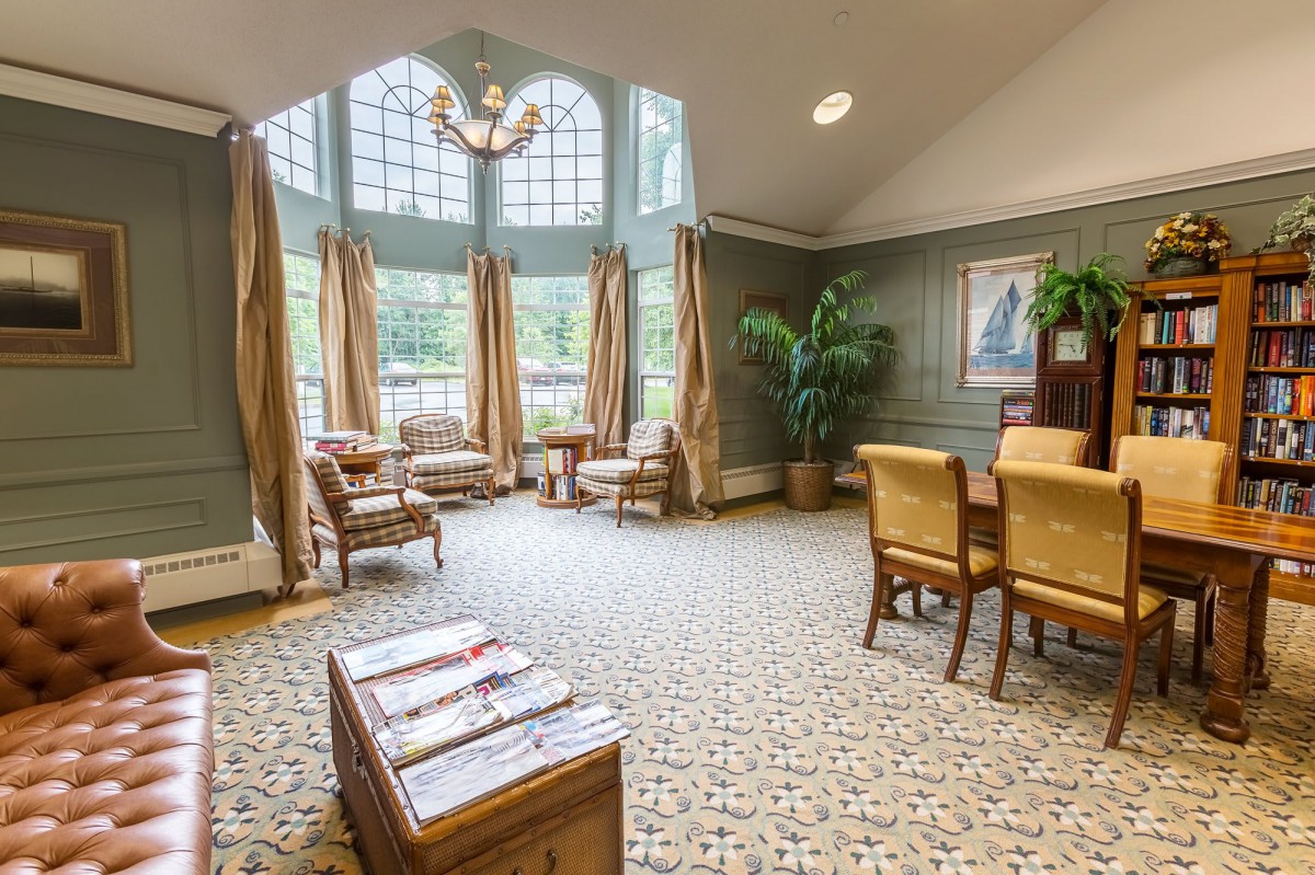 A spacious and elegantly decorated living room featuring large windows, comfortable seating, and a warm ambiance.