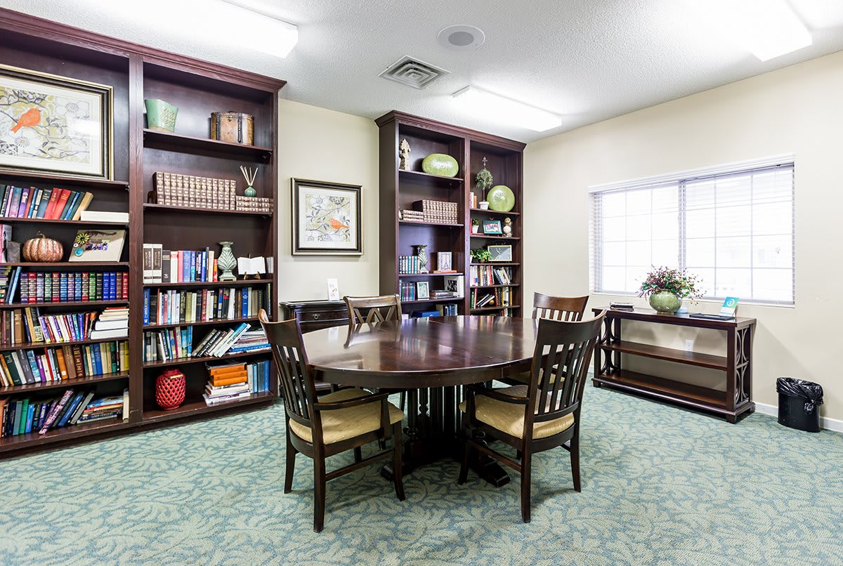 A cozy library space with bookshelves and a round table, ideal for meetings or reading.
