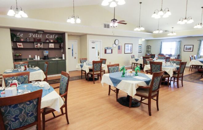 A cozy dining area with neatly arranged tables and chairs under warm lighting.