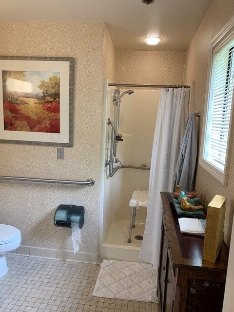An accessible bathroom with a shower, toilet, and artwork on the wall.