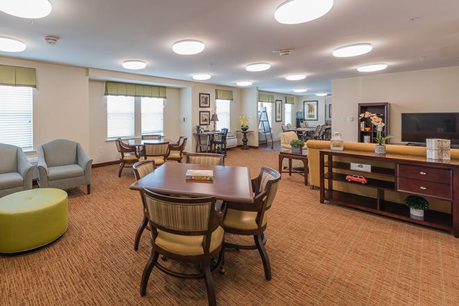 A well-lit and spacious living area with multiple tables and chairs.
