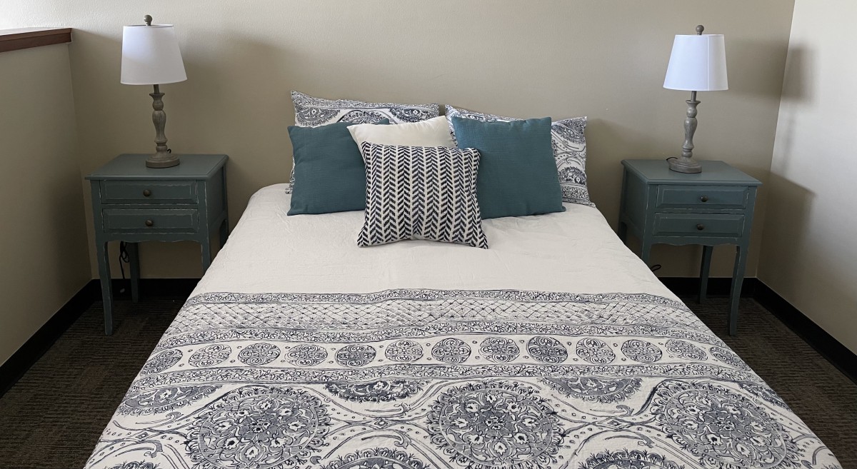 A neatly made bed with decorative pillows and patterned bedding.