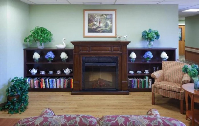Cozy living room with a fireplace, decorated shelves, and comfortable seating.