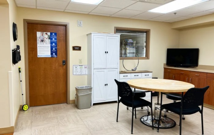 A small office meeting room with a table, chairs, and storage cabinets.