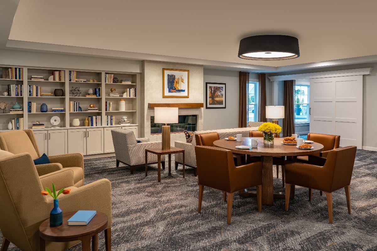 A cozy living room with a library corner featuring comfortable seating and elegant decor.