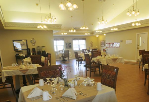 A well-lit dining room with neatly arranged tables and chairs.