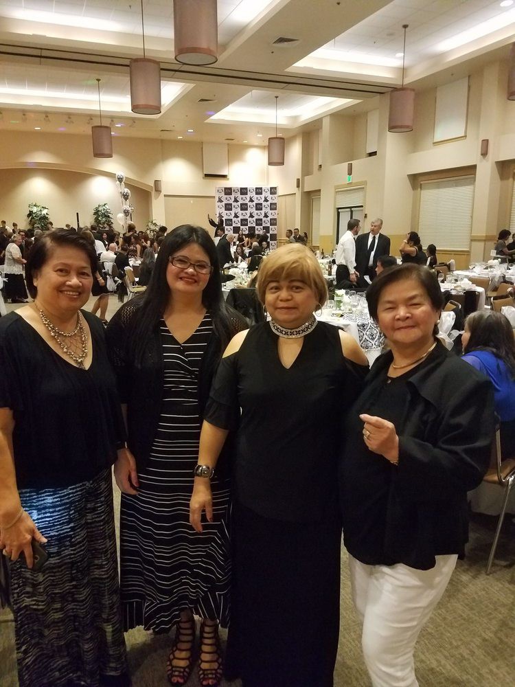 A group of women posing together at an indoor event.