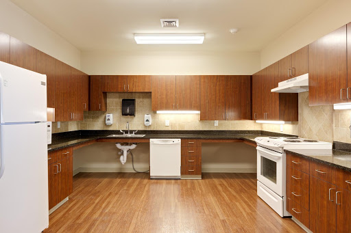 A modern kitchen featuring wooden cabinets, sleek countertops, and essential appliances.