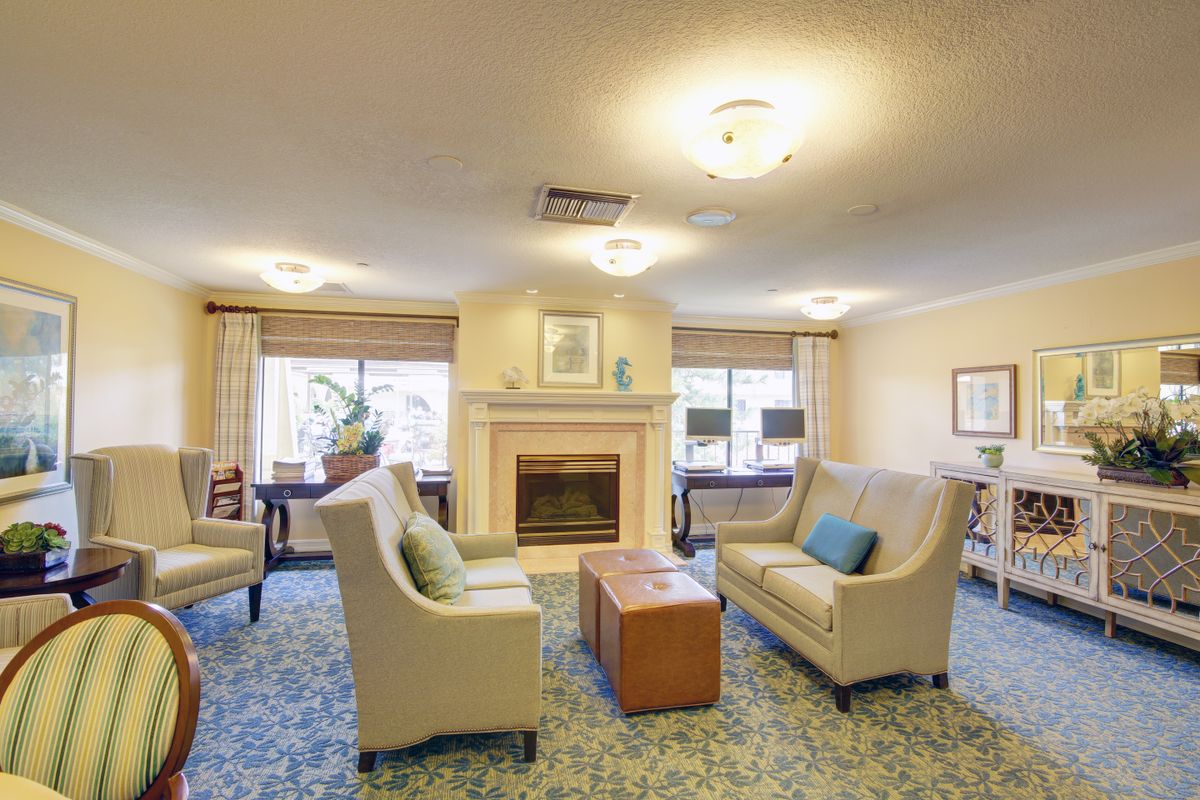 A cozy living room with sofas, a fireplace, and large windows.