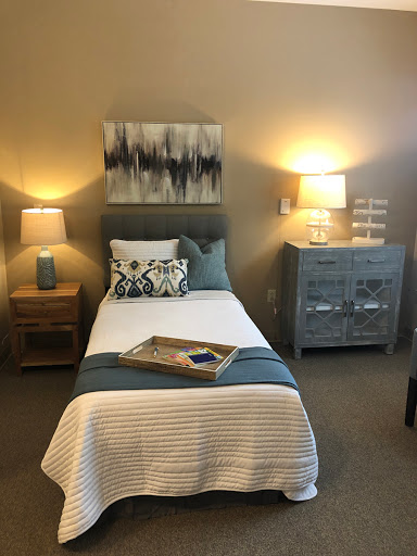 A cozy and modern bedroom featuring a single bed, stylish nightstands, and warm lighting.