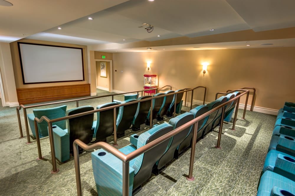 A cozy home theater with tiered seating facing a large projector screen.