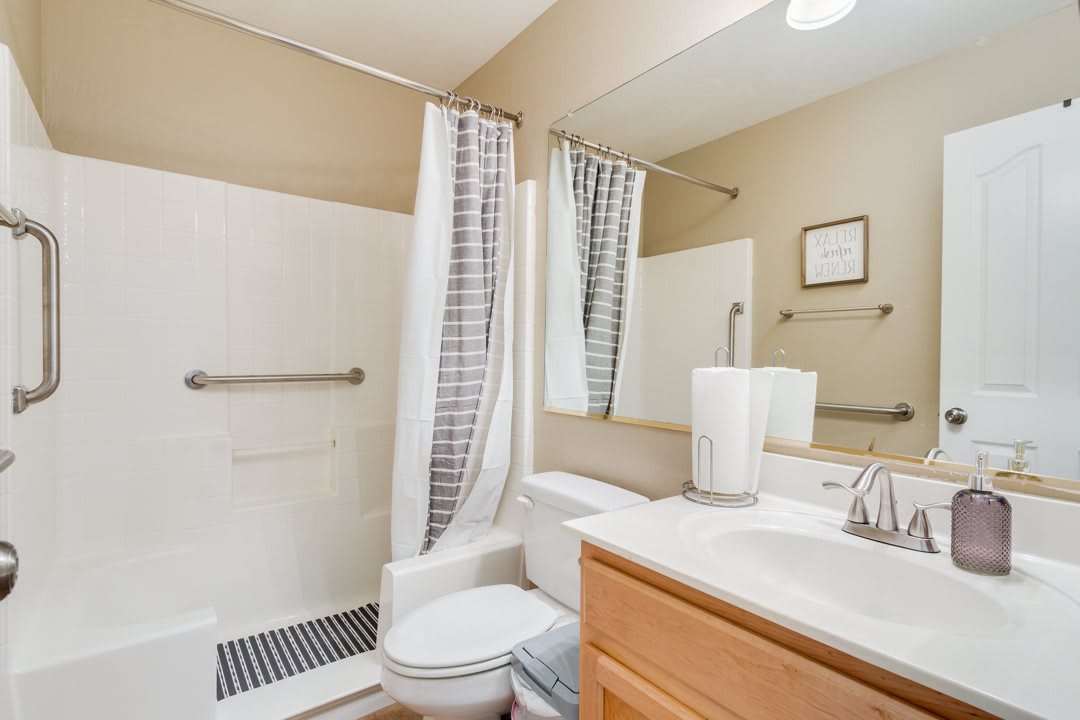 A clean and simple bathroom with a shower, toilet, and sink.
