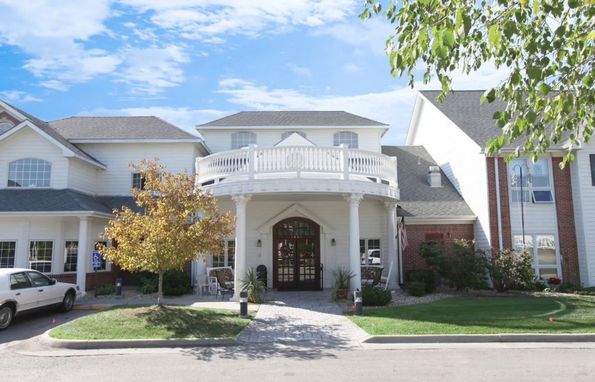 A two-story suburban house with a prominent entrance and well-maintained lawn.