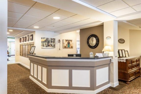A well-lit reception area with a modern desk and decorative elements.