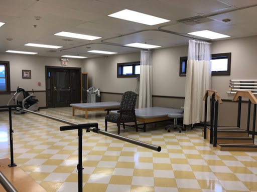 A spacious and well-lit physical therapy room equipped for rehabilitation exercises.