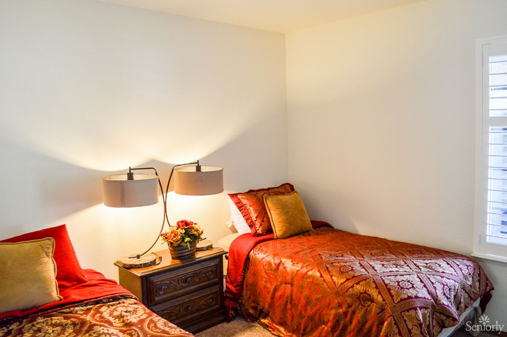 A cozy bedroom with two twin beds and a shared nightstand.